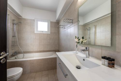 uma casa de banho com um lavatório, uma banheira e um WC. em Accomoteleia Crystal Lagoon Villa em Protaras