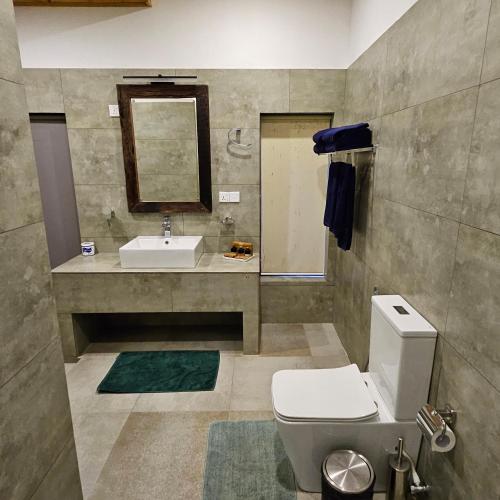 a bathroom with a toilet and a sink at Ella Planters Bungalow in Ella