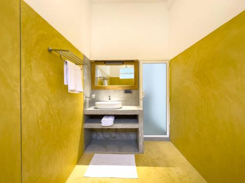 a bathroom with a sink and a mirror at Moringa Mirissa in Mirissa