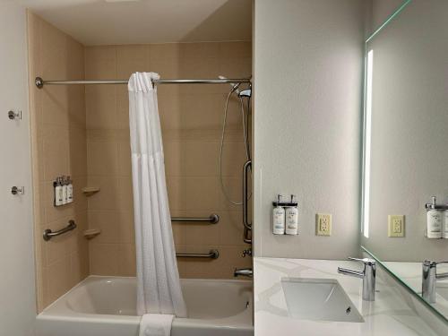 a bathroom with a tub and a shower and a sink at Staybridge Suites Milwaukee West-Oconomowoc by IHG in Oconomowoc