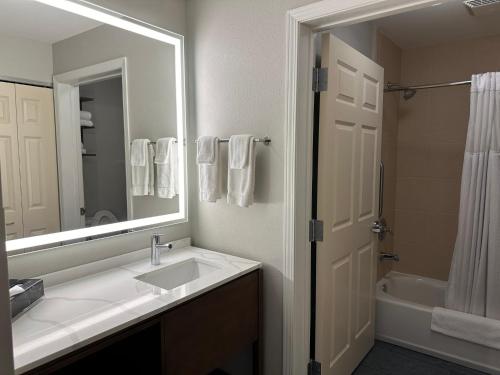 a bathroom with a sink and a mirror and a tub at Staybridge Suites Milwaukee West-Oconomowoc by IHG in Oconomowoc