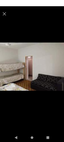 Habitación pequeña con 2 camas y pasillo en Departamentos Necochea en Godoy Cruz