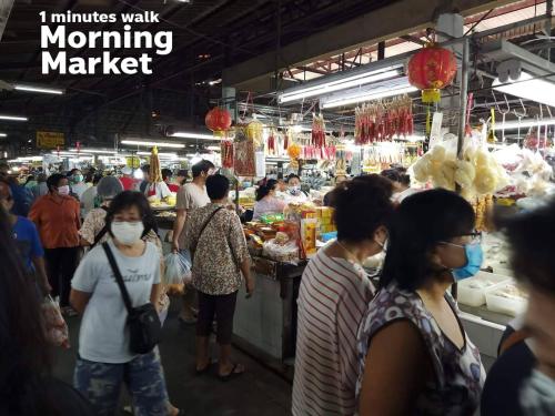 people in a market wearing face masks at Youyen Hostel in Ban Don Muang