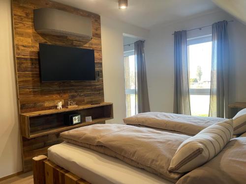a bedroom with two beds and a flat screen tv at Arnfels Residences am Tor zur Südsteirischen Weinstraße in Arnfels