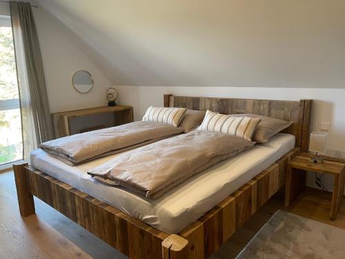 a large wooden bed in a room with a window at Arnfels Residences am Tor zur Südsteirischen Weinstraße in Arnfels