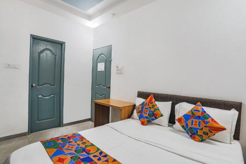 a bedroom with a bed and a green door at FabExpress Pramila Prakash in Nagpur