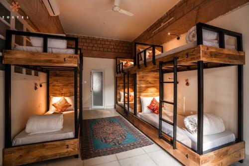 two bunk beds in a room with wooden walls at Zostel Jodhpur (Ratanada) in Jodhpur