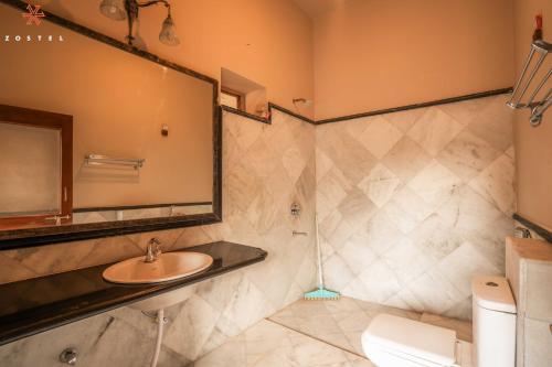 a bathroom with a sink and a mirror and a toilet at Zostel Jodhpur (Ratanada) in Jodhpur