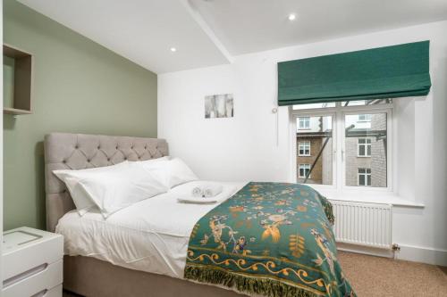 a bedroom with a bed and a window at Stunning 3BD Flat Free Parking close to Greenwich in London