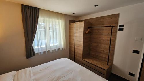 - une chambre avec un lit et un mur en bois dans l'établissement Casa Il Giardino, à Pozza di Fassa