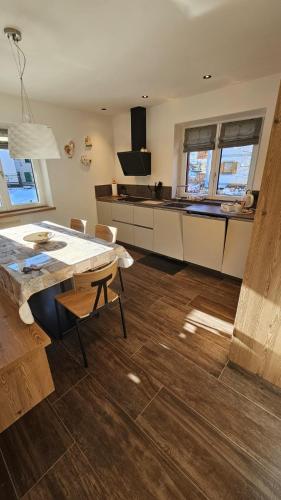 a kitchen with a wooden floor and a table at Casa Il Giardino in Pozza di Fassa