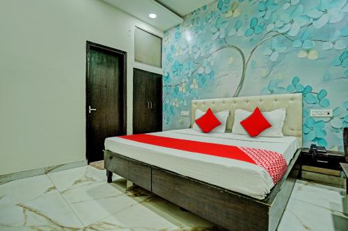 1 dormitorio con 1 cama con almohadas rojas en OYO Flagship Hotel Sangam Palace, en Bamrauli