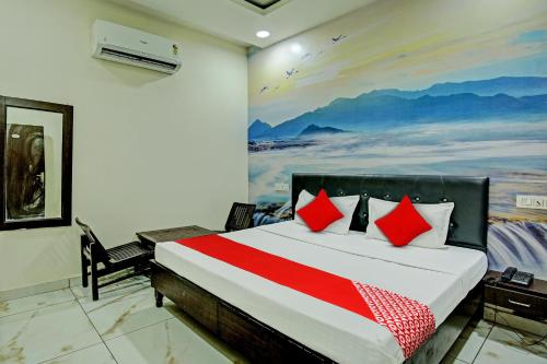 una camera da letto con un letto e un dipinto sul muro di OYO Flagship Hotel Sangam Palace a Bamrauli