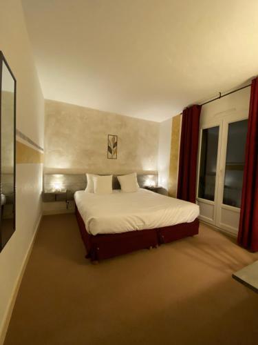 Un dormitorio con una cama grande y una ventana en Logis Hôtel Médiéval, Montélimar Nord, en Rochemaure
