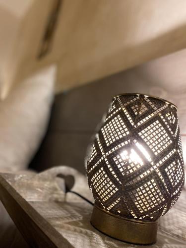 a lamp sitting on a table next to a bed at Logis Hôtel Médiéval, Montélimar Nord in Rochemaure