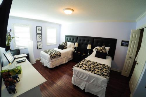 a bedroom with two beds and a table with a desk at Blue Skies Bed & Breakfast in Niagara-on-the-Lake