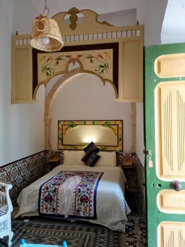 a bedroom with a bed and a green door at Dar Baaziz 3 in Sousse