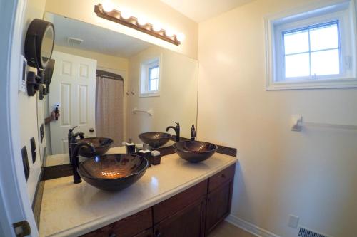 a bathroom with three vessel sinks on a counter at Blue Skies Bed & Breakfast in Niagara on the Lake