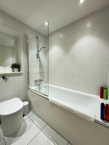 a bathroom with a tub and a toilet and a shower at Contemporary 2BD Flat wBalcony Canary Wharf! in London
