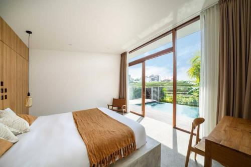 ein Schlafzimmer mit einem Bett und einem großen Fenster in der Unterkunft Villa Lennon - Tropical 3 Bedroom Villa Facing The Rice fields in Canggu