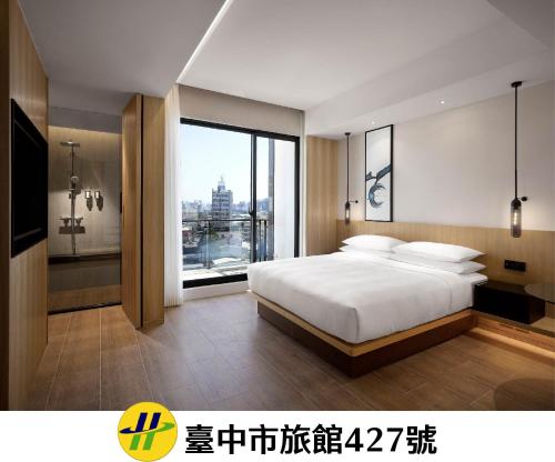 a bedroom with a large bed and a large window at Fairfield by Marriott Taichung in Taichung