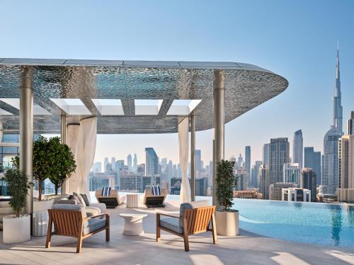 een zwembad op het dak van een gebouw met een stad bij The Lana - Dorchester Collection in Dubai