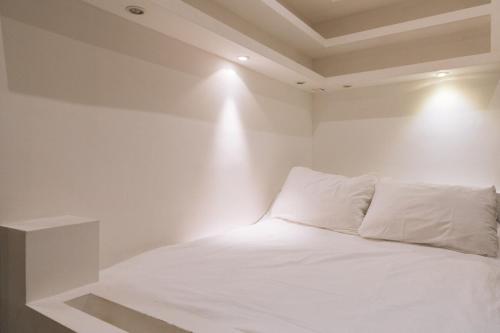 - une chambre avec des murs blancs et un lit avec des oreillers blancs dans l'établissement Cosy & Stylish Large Studio VoltaireOberkampf!, à Paris