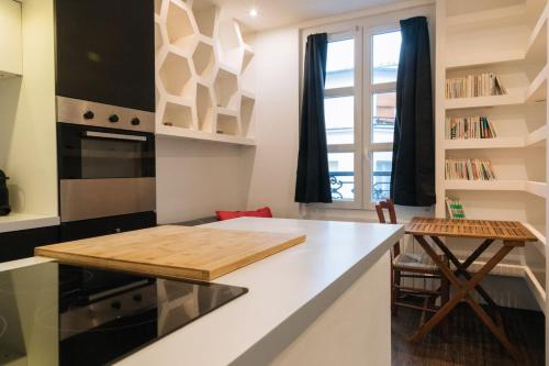 une cuisine avec une planche de coupe en bois sur un comptoir dans l'établissement Cosy & Stylish Large Studio VoltaireOberkampf!, à Paris