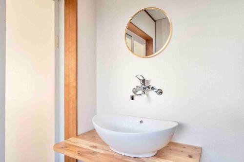 a bathroom with a white sink and a mirror at Takii Motomachi Irodori House in Osaka