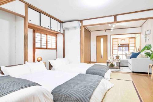 a bedroom with two beds and a living room at Takii Motomachi Irodori House in Osaka