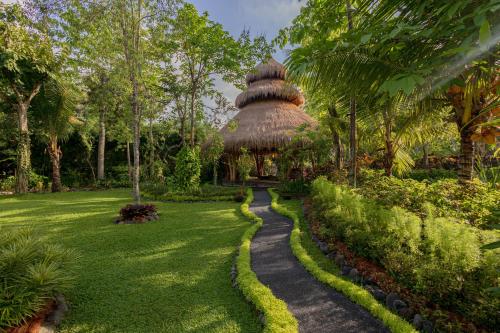 a path leading to a hut in a garden at Fivelements Retreat Bali, Ubud in Ubud