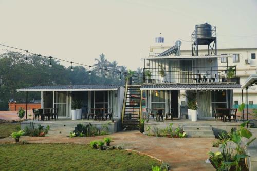 a building with a patio with tables and chairs at Out of Box Living Kashid,Murud in Kashid