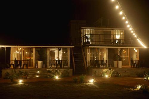 a house with a balcony at night with lights at Out of Box Living Kashid,Murud in Kashid