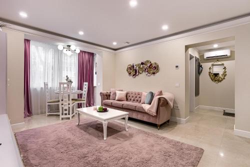 a living room with a couch and a table at Sika DeLuxe Apartment Arad in Arad
