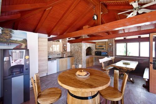 una cucina e una sala da pranzo con tavolo in legno di Apartmani Kičuda a Banjol