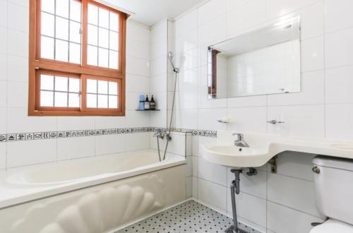 a bathroom with a sink and a tub and a toilet at Nokwon Motel in Jeju