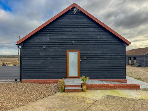 a black building with a door on top of it at Brooke View Barns No 1 in Norwich