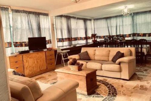 ein Wohnzimmer mit einem Sofa und einem TV in der Unterkunft Grutas Tolantongo enixmiquilpan Casamuygde 10camas in Ixmiquilpan
