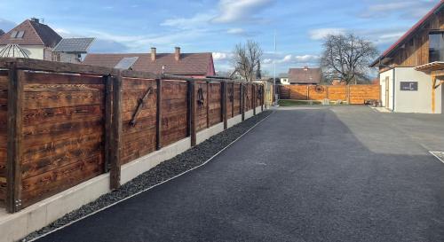 a wooden fence next to a street with houses at Arnfels Residences am Tor zur Südsteirischen Weinstraße in Arnfels