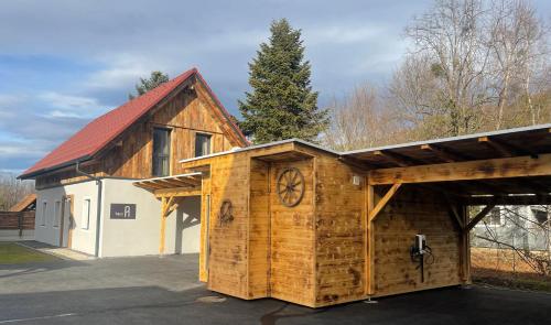 a wooden building with a clock on the side of it at Arnfels Residences am Tor zur Südsteirischen Weinstraße in Arnfels