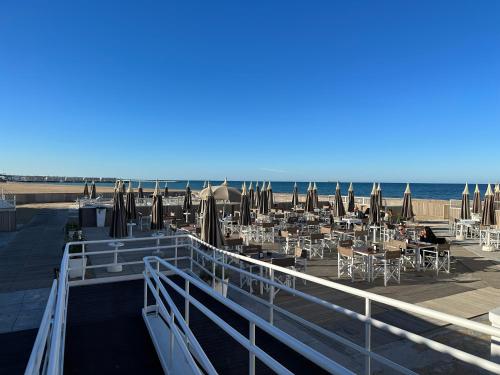 a beach with tables and umbrellas and the ocean at Il Gelsomino luxury suites in Bari