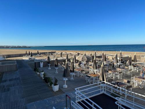una playa con mesas y sombrillas y el océano en Il Gelsomino luxury suites, en Bari