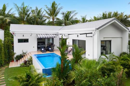 a white house with a swimming pool in front of it at Bougain Villas in Salad Beach