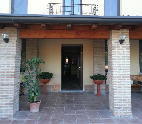a front porch of a house with potted plants at B&B La Viola in Castelvetro Piacentino