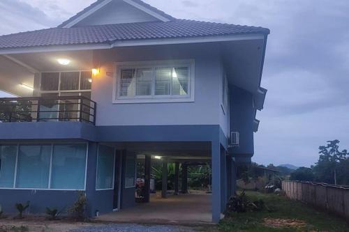 a blue house with a window and a fence at กิติ์ชาวิว วิลล่า in Ban Nang Lae
