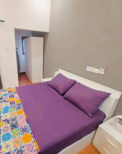 a bed with purple sheets and pillows in a room at Les 9 Plurielles - Studio 2 KPALIME KOUMA KONDA in Palimé