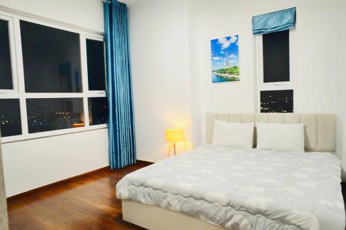 1 dormitorio con cama blanca y ventana grande en Căn hộ 2PN, 2WC tầng 25 2 bedrooms luxury apartment, en Ho Chi Minh