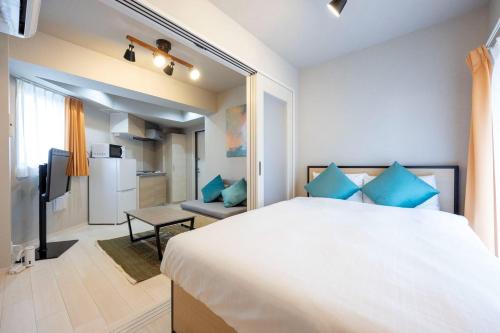 a bedroom with a large bed with blue pillows at Mat Hikifune in Tokyo