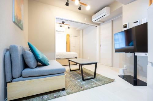 a living room with a blue couch and a table at Mat Hikifune in Tokyo