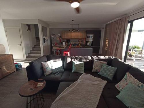 sala de estar con sofá y cocina en Ravissante maison sur les hauteurs, en Faaa